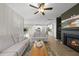 Open-concept living room connects to a modern kitchen with a cozy fireplace and ceiling fan at 251 Olde Pl, Zebulon, NC 27597