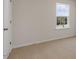 Bedroom features a large window and neutral colored carpet at 281 Hanging Elm Ln, Fuquay Varina, NC 27526