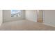 Bright bedroom with neutral carpet, a large window, and an open doorway at 281 Hanging Elm Ln, Fuquay Varina, NC 27526