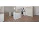 Well-lit kitchen boasts a center island, stainless appliances, and wood-look floors at 298 Hanging Elm Ln, Fuquay Varina, NC 27526