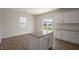 Sunlit kitchen with a central island, white cabinets, and stainless steel accents at 298 Hanging Elm Ln, Fuquay Varina, NC 27526