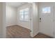 Bright entryway with wood-look floors, neutral walls, and a view of a white entry door at 298 Hanging Elm Ln, Fuquay Varina, NC 27526