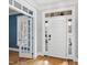 Bright foyer featuring hardwood floors, a white front door, and transom windows at 310 Millsfield Drive Dr, Cary, NC 27519