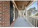 Inviting front porch with brick accents, a wooden ceiling, and painted wood flooring at 310 Millsfield Drive Dr, Cary, NC 27519
