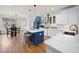Open kitchen featuring a blue island, white cabinets, stainless steel appliances and hardwood floors at 310 Millsfield Drive Dr, Cary, NC 27519
