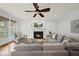 Inviting living room with a fireplace, large sectional sofa, and a ceiling fan at 310 Millsfield Drive Dr, Cary, NC 27519