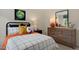 Comfortable bedroom featuring a bed with grid-patterned bedding and a wooden dresser at 311 Hanging Elm Ln, Fuquay Varina, NC 27526
