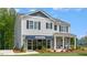 Inviting two-story home features stone accents, shutters, and a professionally landscaped front yard at 311 Hanging Elm Ln, Fuquay Varina, NC 27526