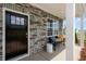 Inviting front porch features a stone wall, comfortable bench, and stylish decor, enhancing curb appeal at 311 Hanging Elm Ln, Fuquay Varina, NC 27526