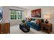 Comfortable living room with a teal sofa, wooden side table, and a view of the green outdoors at 311 Hanging Elm Ln, Fuquay Varina, NC 27526