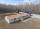 Aerial view of charming home with bricked underpinning, storage shed, and large shop building with carport at 341 Acorn Ct, Rougemont, NC 27572
