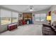 Spacious living room with stone fireplace, plush carpet, and ample natural light from large windows at 341 Acorn Ct, Rougemont, NC 27572