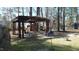 Serene backyard featuring a pergola-covered seating area, bird feeders and a surrounding wooded landscape at 3510 Middlebrook Dr, Durham, NC 27705