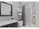 Neutral toned bathroom featuring a shower with decorative tiles and a marble countertop sink at 3510 Middlebrook Dr, Durham, NC 27705