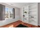 Bedroom with hardwood floors, built in shelves, and a window with views of the yard at 3510 Middlebrook Dr, Durham, NC 27705