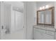 Bathroom featuring a granite countertop, framed mirror, and tub with tile surround at 5025 Fanyon Way, Raleigh, NC 27612