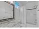 Clean bathroom featuring a granite countertop, framed mirror, and tub with tile surround at 5025 Fanyon Way, Raleigh, NC 27612