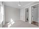 A sunny bedroom showcasing neutral tones, carpeted floor, and ensuite bathroom entrance at 5025 Fanyon Way, Raleigh, NC 27612