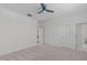 Bright bedroom with neutral walls, carpet, ceiling fan and a view to the home's bathroom at 5025 Fanyon Way, Raleigh, NC 27612