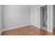 An empty bedroom with hardwood floors and a double door closet that leads to the bathroom at 5025 Fanyon Way, Raleigh, NC 27612