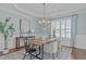 Airy dining room features modern chandelier, wainscoting, and large windows with shutter at 5025 Fanyon Way, Raleigh, NC 27612