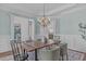 Open dining room with modern chandelier, wainscoting, and seamless access to other living spaces at 5025 Fanyon Way, Raleigh, NC 27612