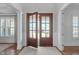Bright entryway features hardwood floors, paneled walls, and striking double doors with glass panes at 5025 Fanyon Way, Raleigh, NC 27612