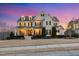 Beautiful two-story home with manicured lawn, covered porch, and warm exterior lighting at twilight at 5025 Fanyon Way, Raleigh, NC 27612