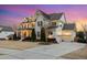 Charming two-story home with warm exterior lighting, attached garage and meticulously maintained lawn at 5025 Fanyon Way, Raleigh, NC 27612