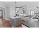 Bright kitchen with white cabinets, gray island, stainless steel refrigerator, and hardwood floors at 5025 Fanyon Way, Raleigh, NC 27612