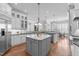 Open kitchen with white cabinetry, marble countertops, pendant lighting, and stainless steel appliances at 5025 Fanyon Way, Raleigh, NC 27612