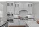 A gourmet kitchen is showcased with white cabinetry, stainless steel appliances, and a stylish backsplash at 5025 Fanyon Way, Raleigh, NC 27612