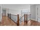 Upper-level landing features hardwood floors, and railings overlooking the main level at 5025 Fanyon Way, Raleigh, NC 27612
