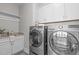 Well-equipped laundry room with washer, dryer, cabinets, and sink at 5025 Fanyon Way, Raleigh, NC 27612