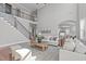 Airy living room with a vaulted ceiling, wrought iron staircase, and an archway to the kitchen at 5025 Fanyon Way, Raleigh, NC 27612
