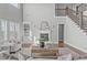 Spacious living room with a fireplace, built-in shelving, and staircase to the second floor at 5025 Fanyon Way, Raleigh, NC 27612