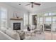 Living room with a white brick fireplace, white sofa and two armchairs, windows, and a sliding glass door at 5025 Fanyon Way, Raleigh, NC 27612