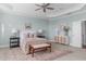 This light-filled main bedroom includes a ceiling fan, neutral decor, and a decorative cabinet at 5025 Fanyon Way, Raleigh, NC 27612