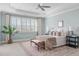 Airy main bedroom featuring a tray ceiling, ceiling fan, and large windows with wooden shutters at 5025 Fanyon Way, Raleigh, NC 27612