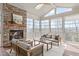 Cozy sunroom featuring a stone fireplace, comfortable seating, and expansive windows for natural light at 5025 Fanyon Way, Raleigh, NC 27612