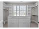 Spacious walk-in closet with custom shelving, drawers, and natural light from a window at 5025 Fanyon Way, Raleigh, NC 27612