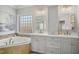 Elegant bathroom features a soaking tub, double vanity, and natural light from the window at 5300 Grand Gate Dr, Raleigh, NC 27613