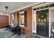Inviting front porch with seating, wreath on door, and brick accents at 5300 Grand Gate Dr, Raleigh, NC 27613
