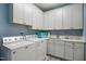 Functional laundry room with white cabinets, sink, counter space, washer and dryer at 5300 Grand Gate Dr, Raleigh, NC 27613