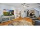Spacious living room with hardwood floors, ceiling fan, and a large television entertainment center at 5300 Grand Gate Dr, Raleigh, NC 27613