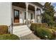 Inviting front porch with elegant columns, a cozy seating area, and a stained wood front door at 543 Guilford Cir, Raleigh, NC 27608