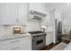 Gourmet kitchen with marble backsplash, stainless steel appliances, and custom cabinetry at 543 Guilford Cir, Raleigh, NC 27608