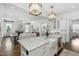 Open-concept kitchen and living room with an island, marble countertops, and stylish lighting at 543 Guilford Cir, Raleigh, NC 27608