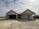 An incomplete charming one-story home featuring a two-car garage under a cloudy sky at 56 Bailey-Boykin Rd, Selma, NC 27576