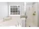 Bright bathroom featuring soaking tub, shower, and large window at 6100 Paducah Dr, Raleigh, NC 27610
